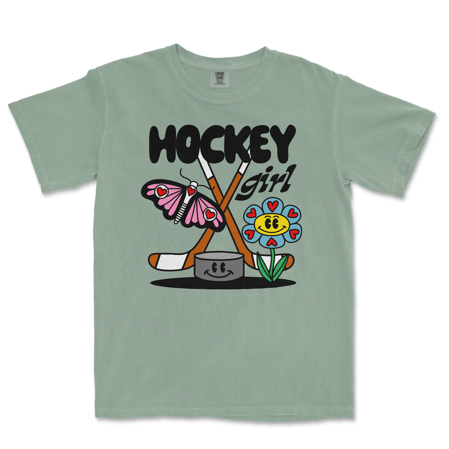 Light green Comfort Colors tee featuring a colorful cartoon design of a butterfly, flower, hockey sticks, and the text "Hockey Girl.