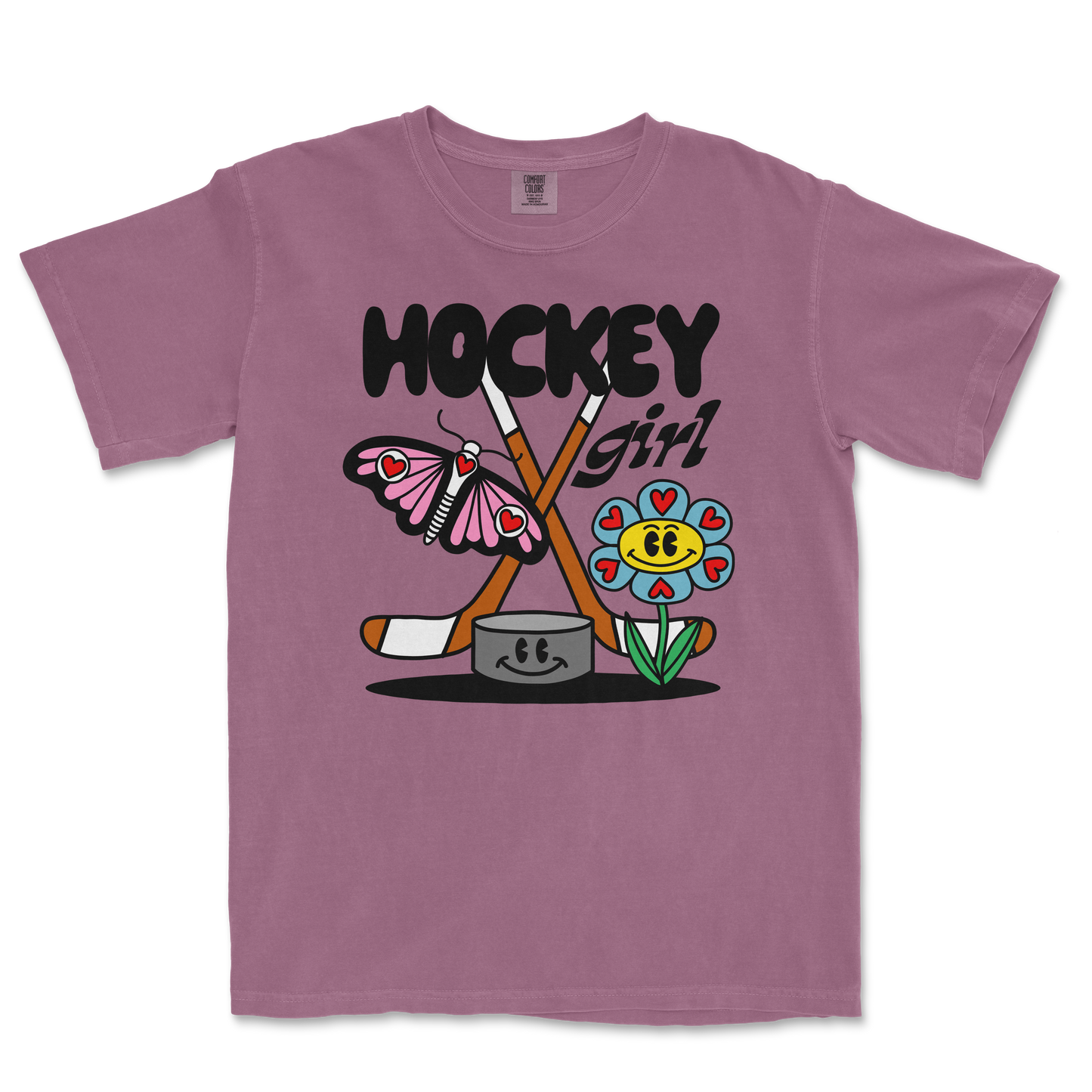 Pink Comfort Colors tee featuring a colorful cartoon design with a butterfly, flower, hockey sticks, and the text "Hockey Girl.