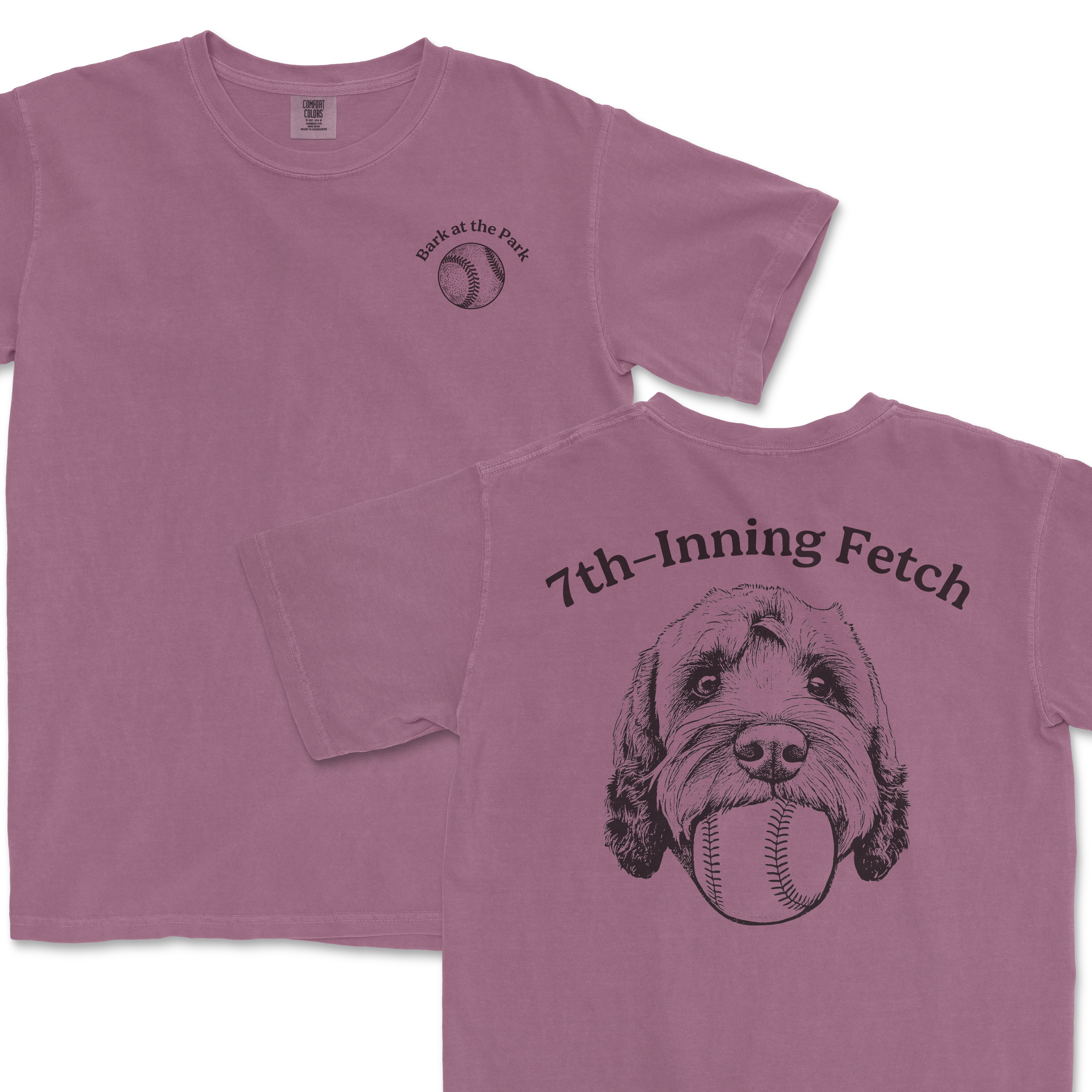 Pink Comfort Colors T-shirt featuring a black illustration of a Goldendoodle with a baseball in its mouth, and text "7th-Inning Fetch" on the back and "Bark at the Park" on the front.