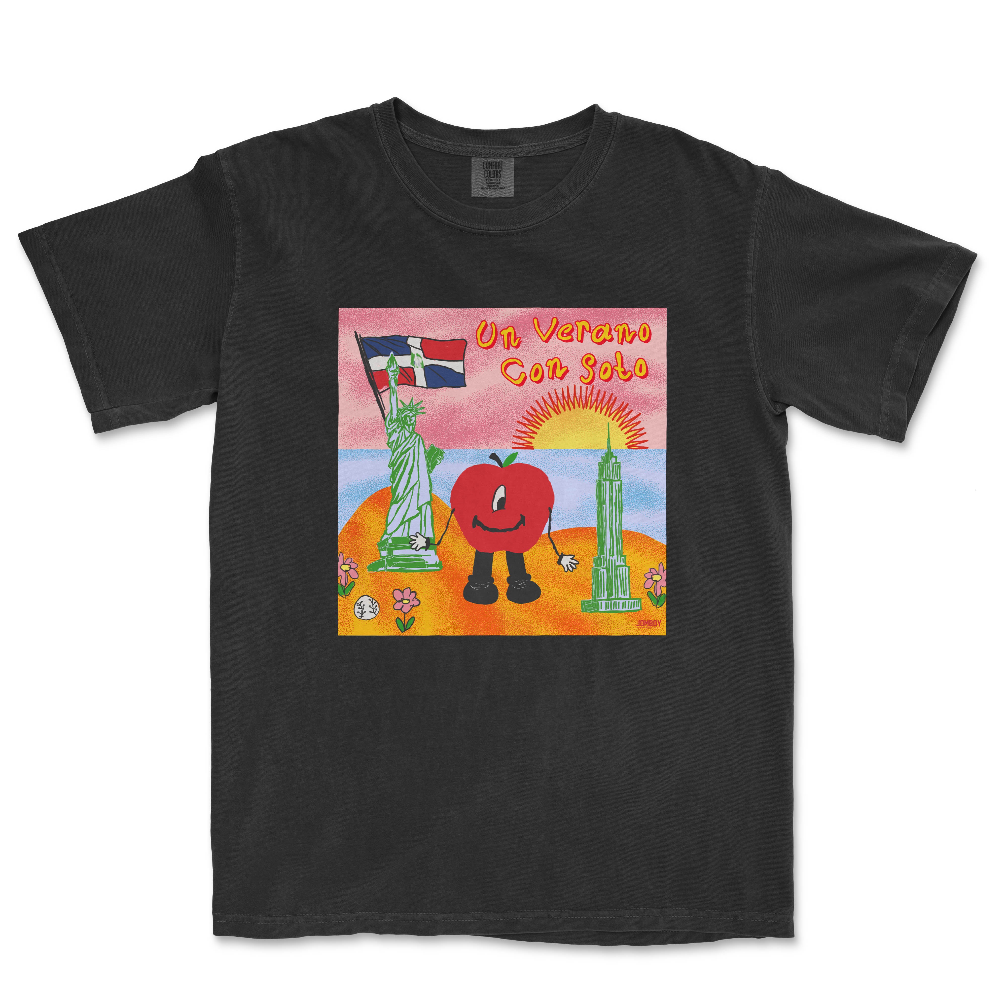Black T-shirt featuring a colorful illustration of a tomato character holding the Statue of Liberty flag, with a sunset, Empire State Building, and flowers, titled "Un Verano Con Soto.