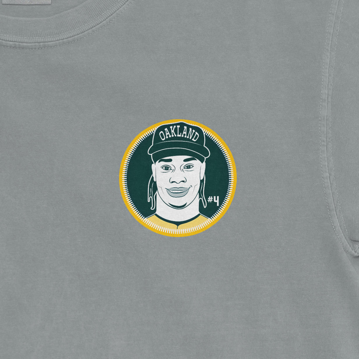 Comfort Colors tee featuring a graphic of Lawrence Butler with "Oakland" cap, #4, and a circular design on a gray background.