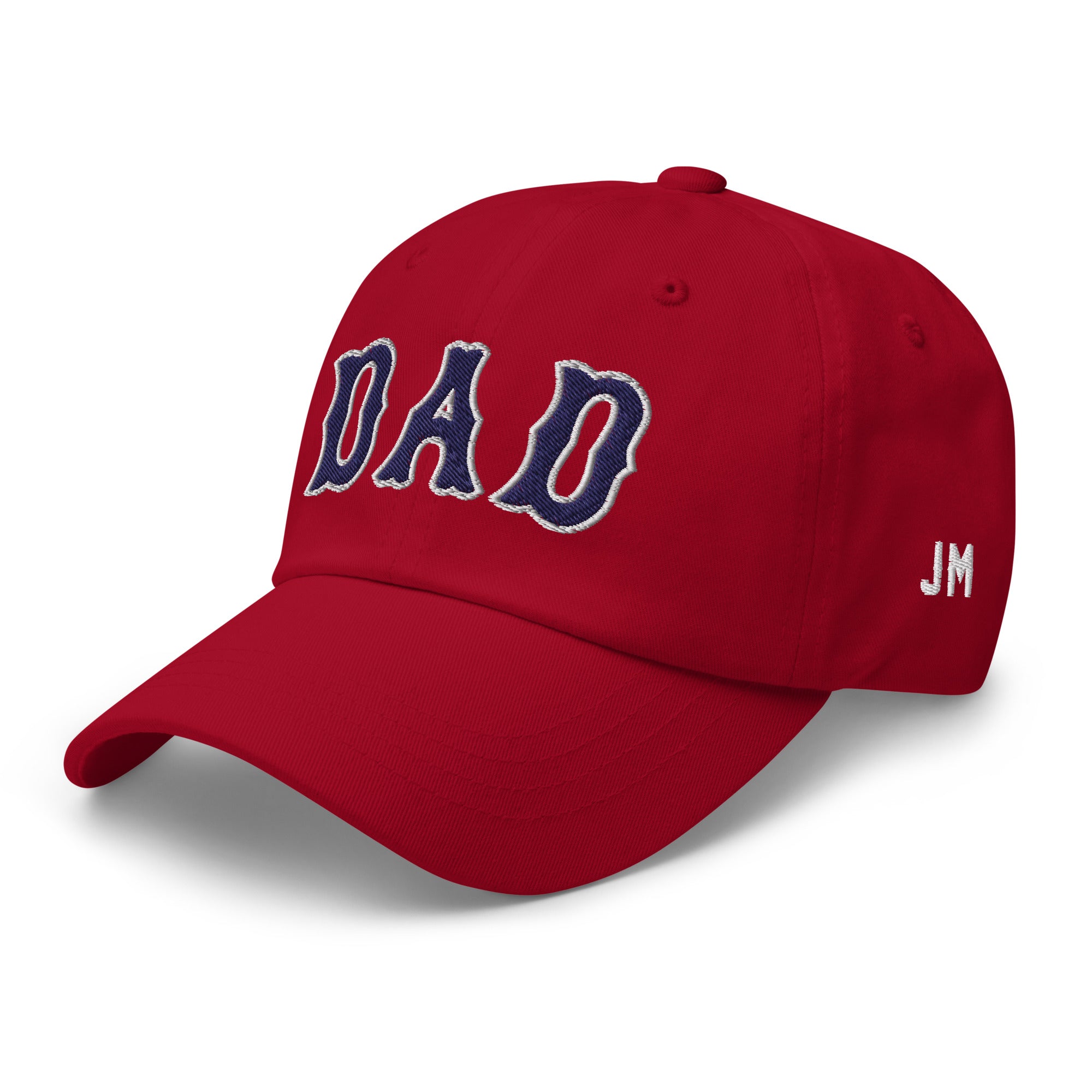 Red dad hat with "DAD" embroidered in navy and white on the front, and "JM" embroidered in white on the side.