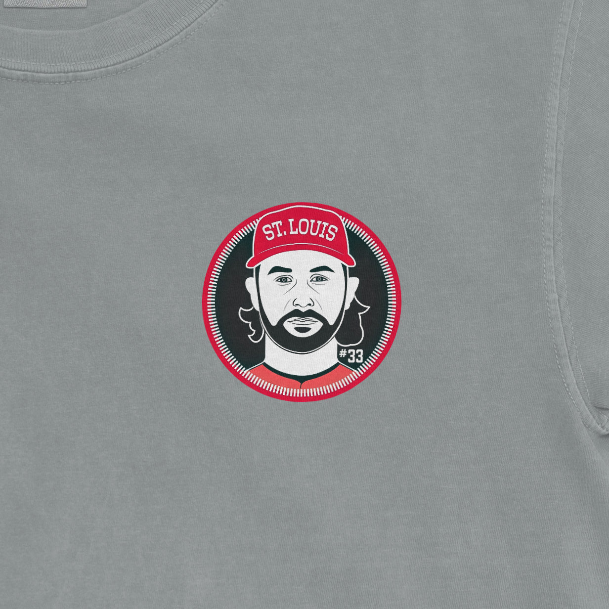 Close-up of a Comfort Colors tee featuring a graphic of Brendan Donovan with a St. Louis cap, number 33, on a light gray fabric.