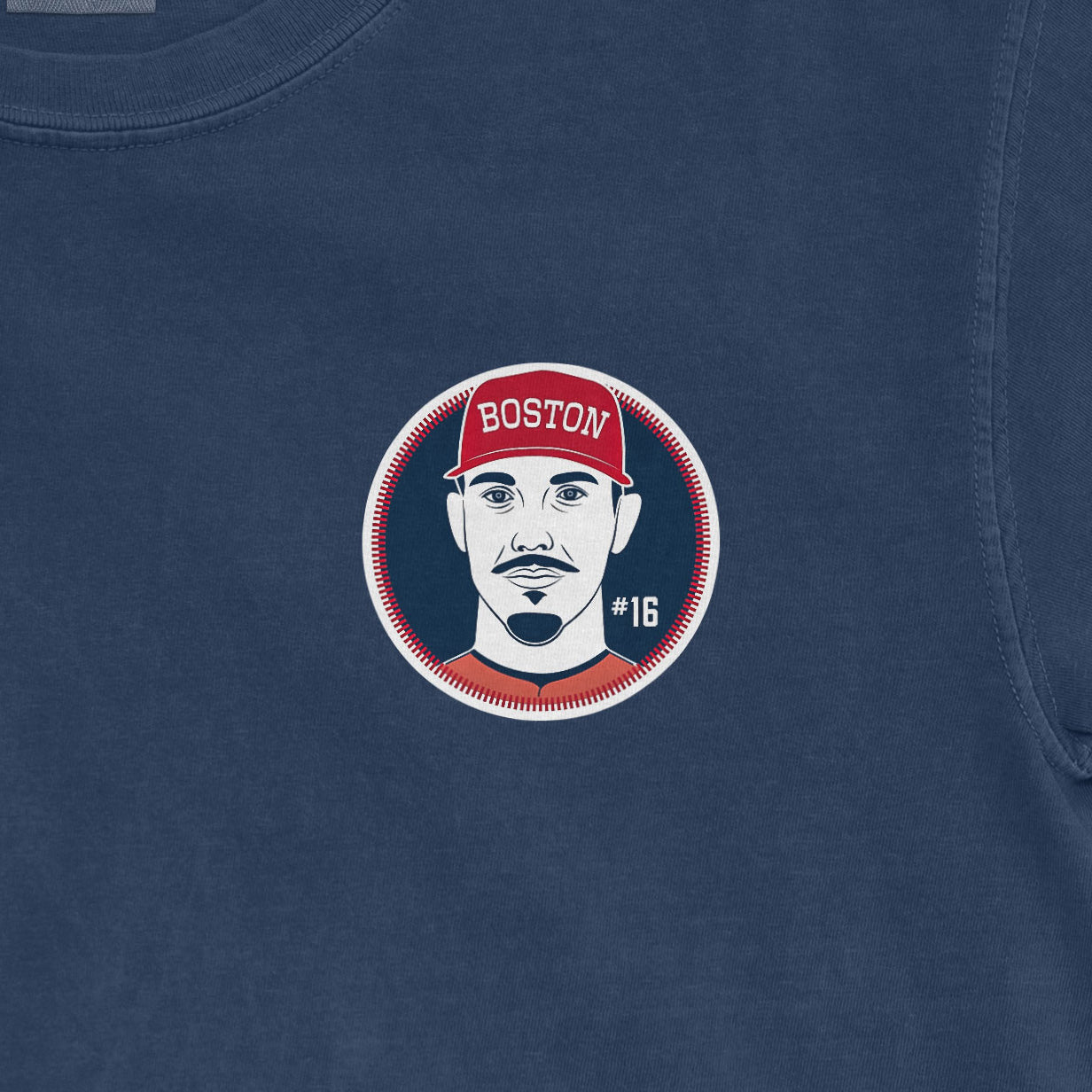 Close-up of a Comfort Colors tee featuring a graphic of Jarren Duran with a Boston cap, #16, on a blue fabric background.