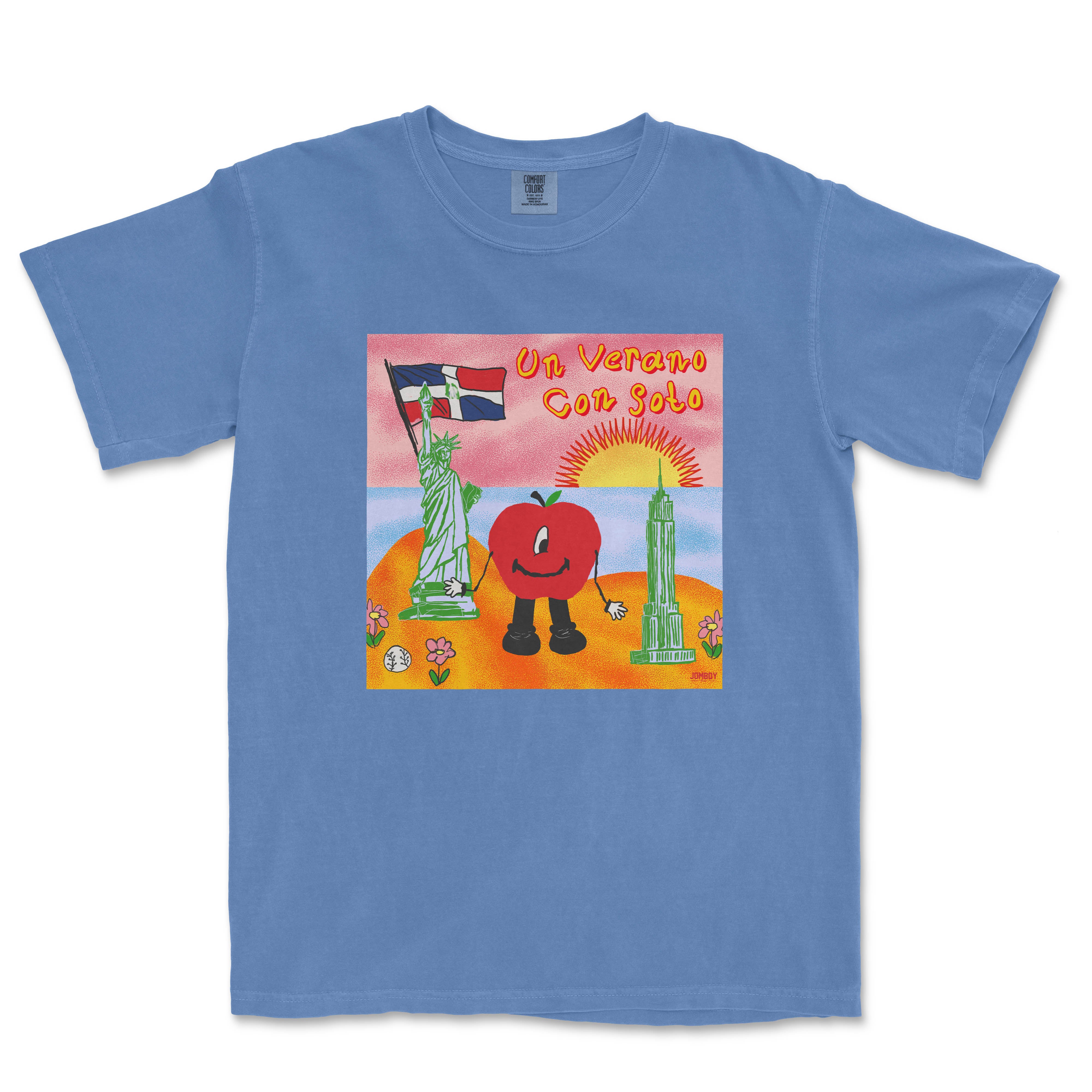 Blue T-shirt featuring a colorful illustration of a smiling tomato character holding a flag, with landmarks, flowers, and a sunset background.