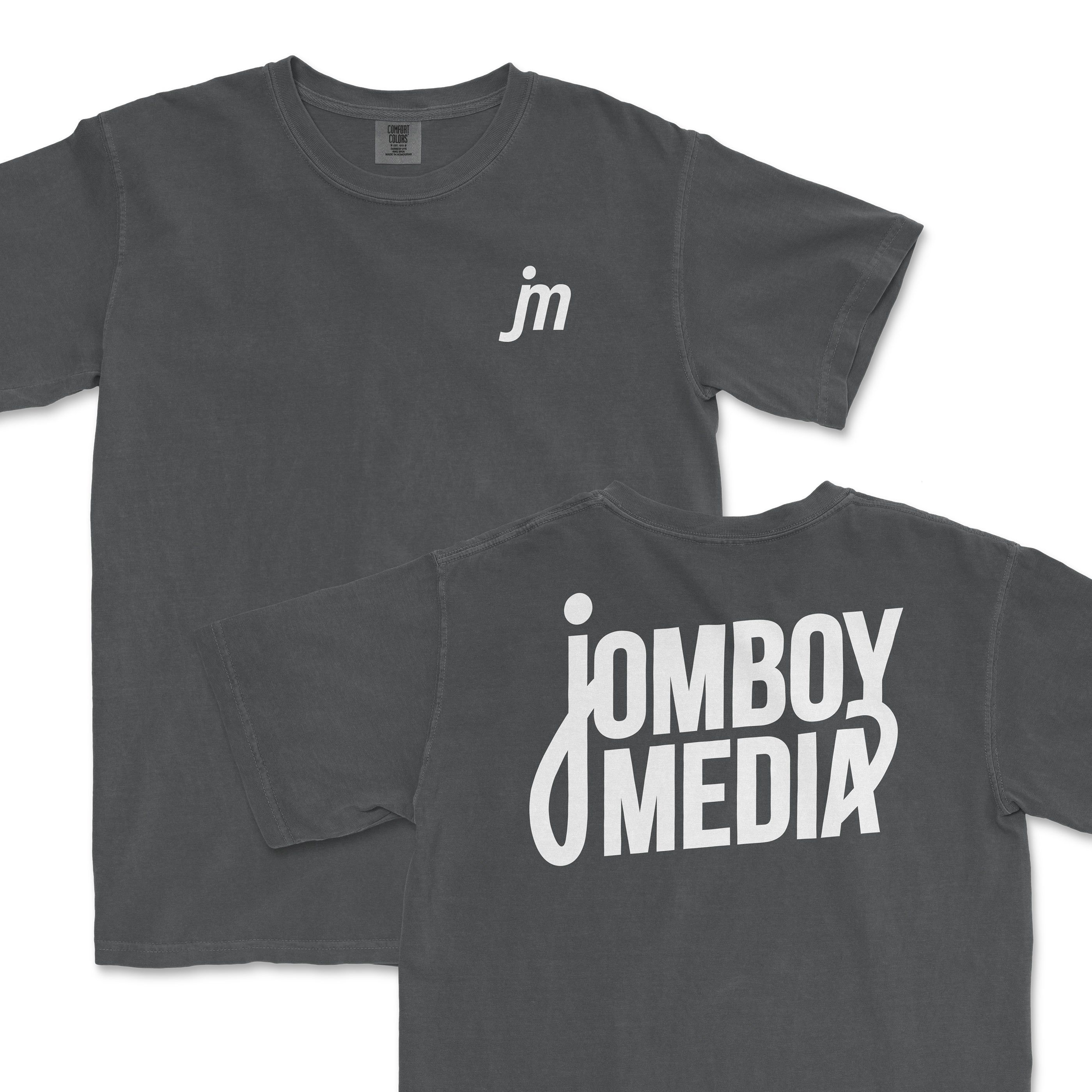 JM Essentials '25 Logo Tee in dark gray featuring a small logo on the front and bold Jomboy Media text on the back.