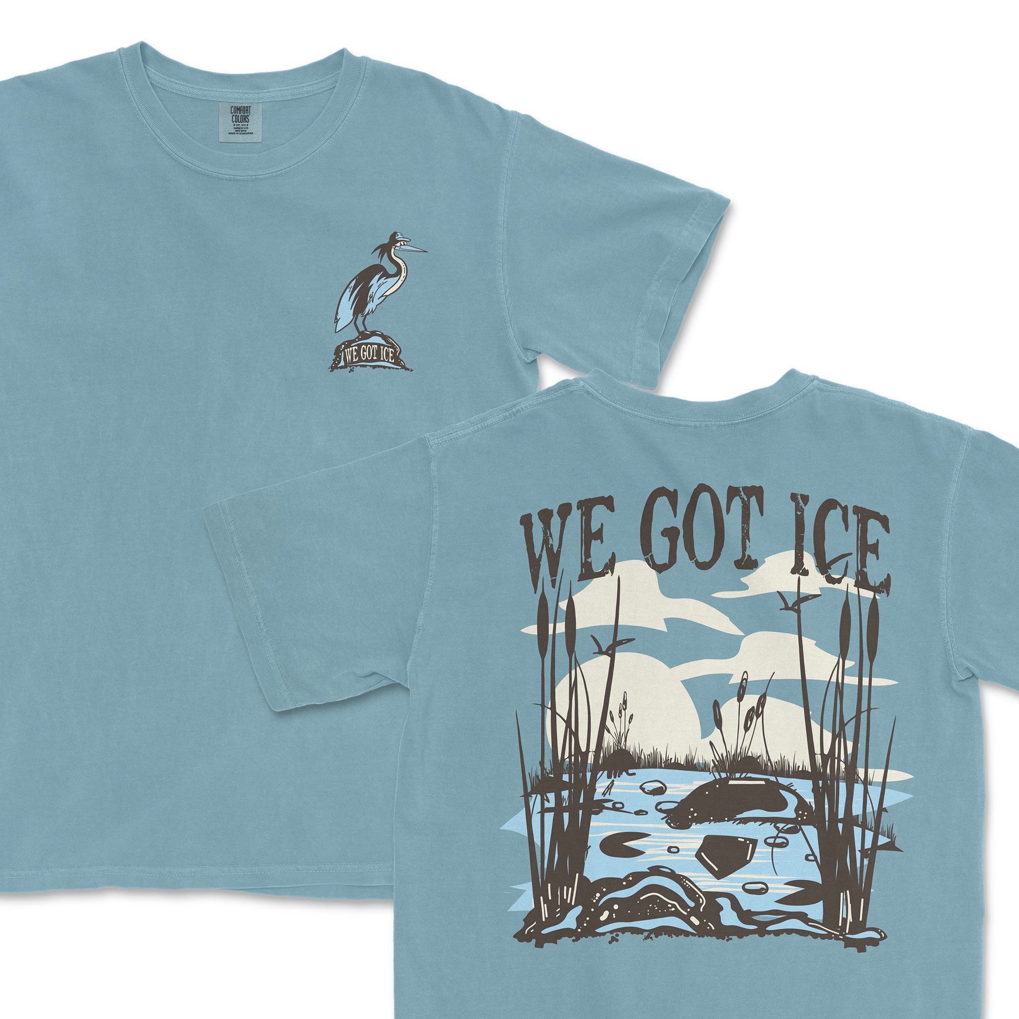 Light blue Comfort Colors T-shirt featuring a heron with "We Got Ice" on the front and a scenic pond with reeds, clouds, and "We Got Ice" text on the back.