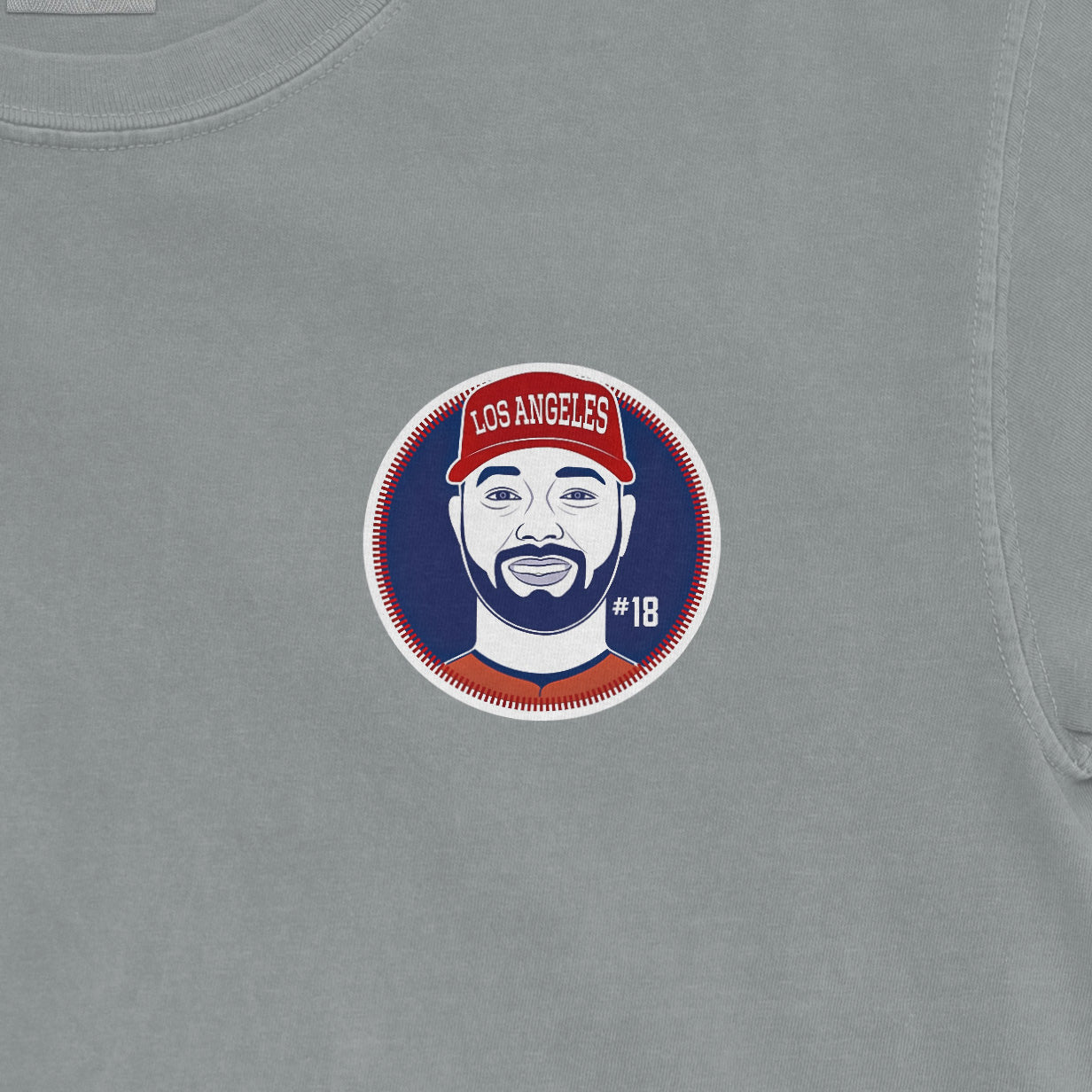 Comfort Colors tee featuring a graphic of Nolan Schanuel with a Los Angeles cap, #18, on a light gray background.