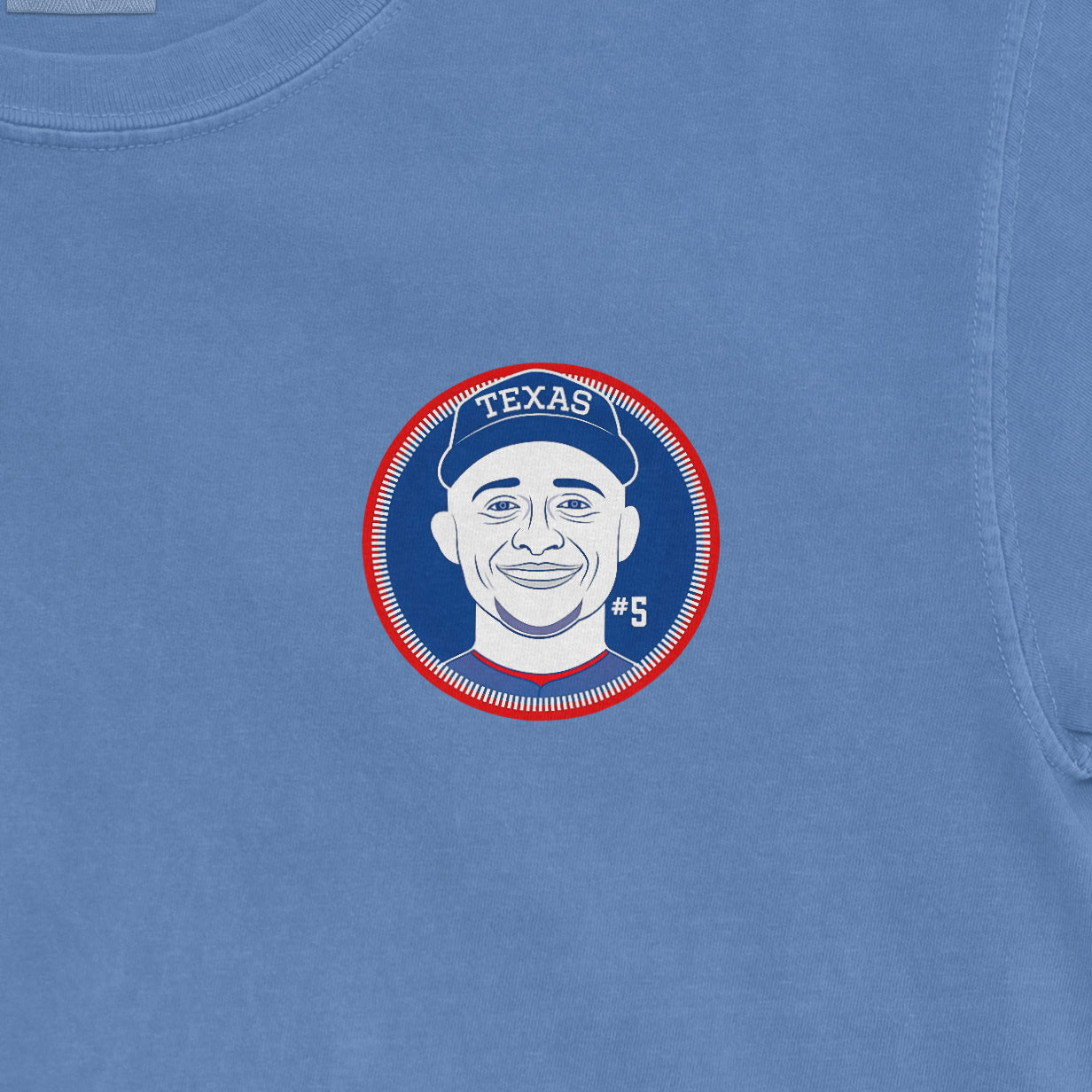 Blue Comfort Colors tee featuring a graphic of Corey Seager's face, "TEXAS" cap, #5 jersey, and circular design.