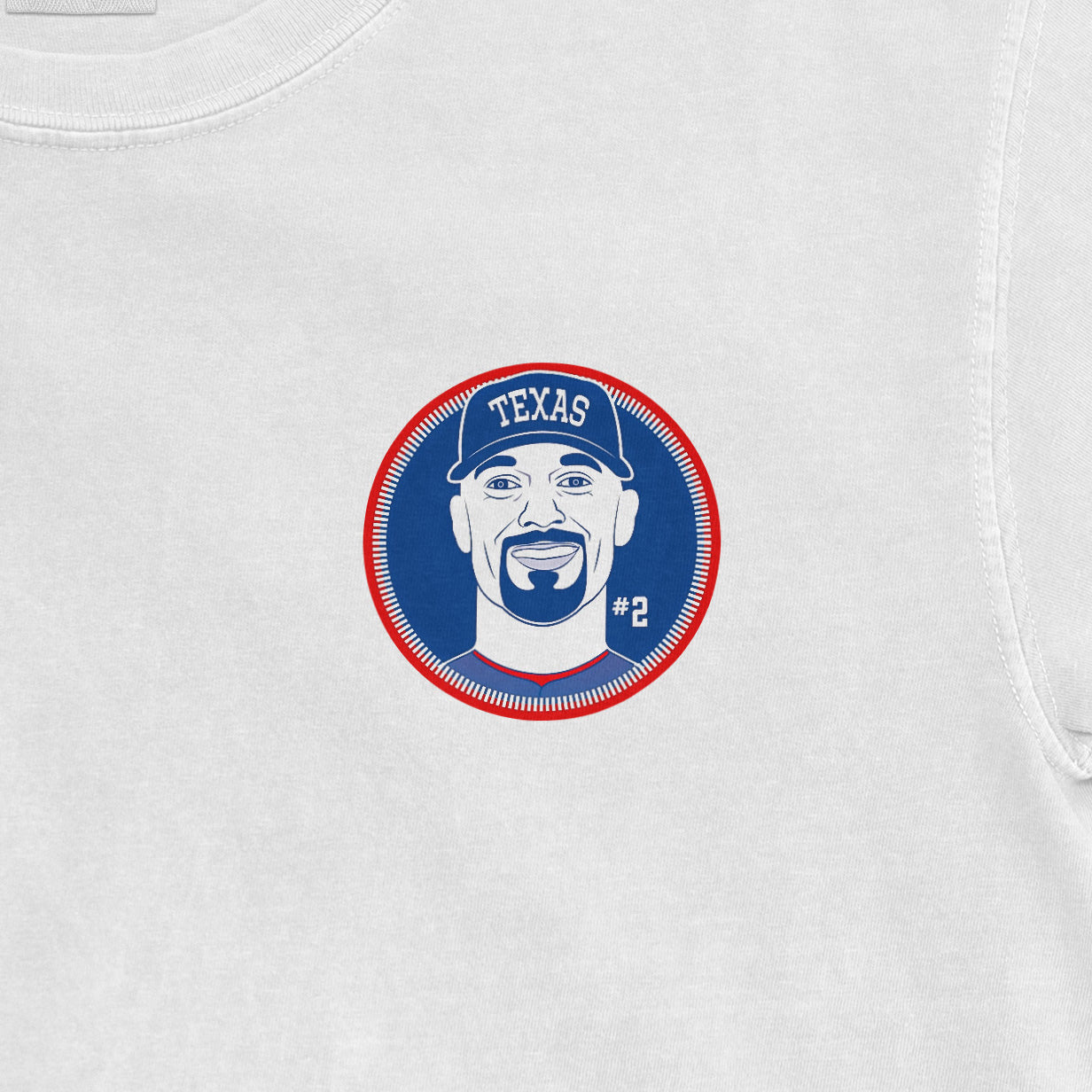 Close-up of a white Comfort Colors tee featuring a Marcus Semien shirsey graphic with a stylized face, "TEXAS" cap, and "#2" on a blue background.