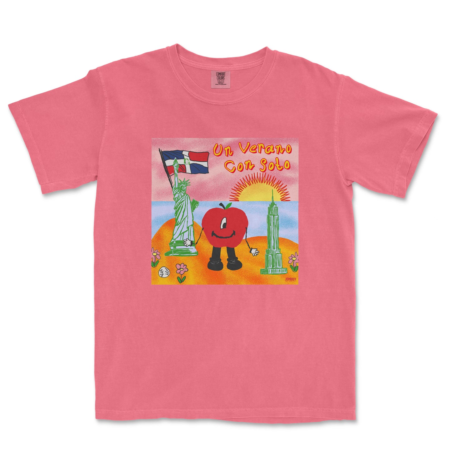 Pink T-shirt featuring a colorful cartoon illustration of a tomato character with arms and legs, holding a flag, with a sunset, Statue of Liberty, and skyscraper in the background, and the text "Un Verano Con Soto.