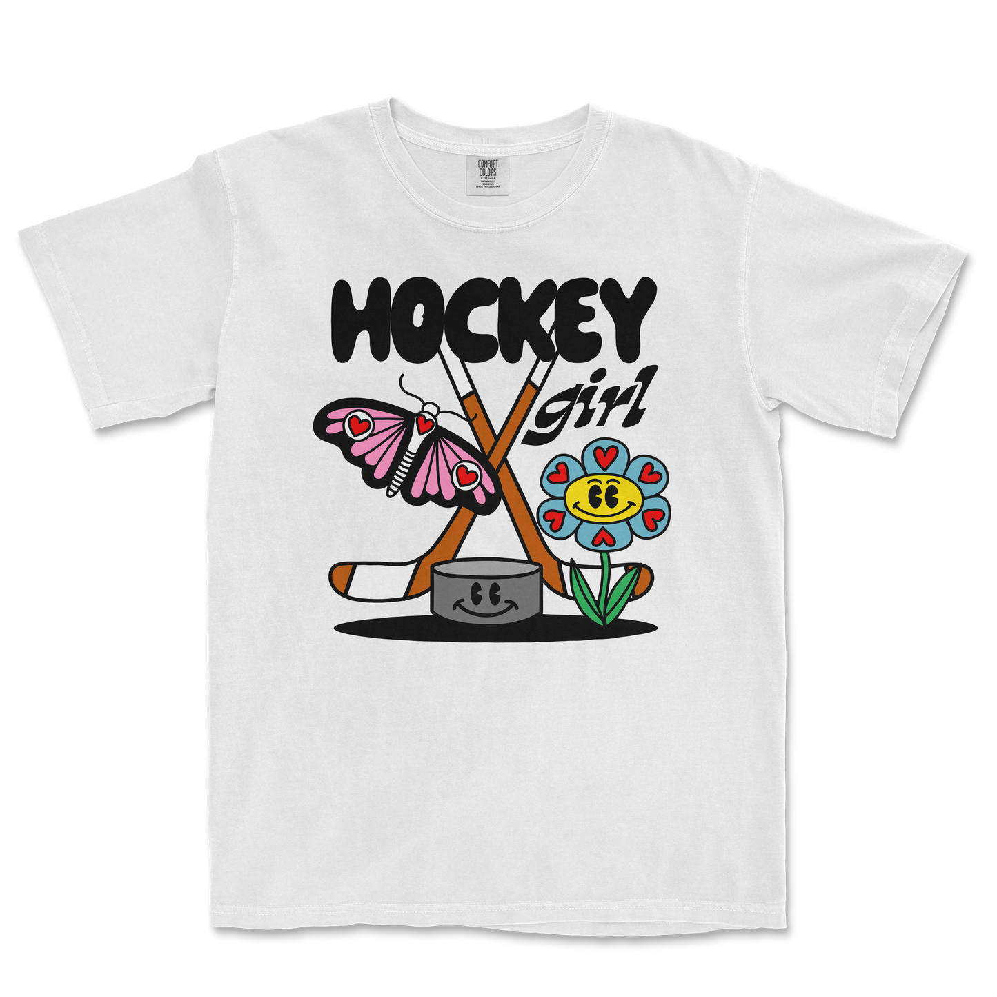 White Comfort Colors tee featuring a colorful cartoon design of a butterfly, flower, hockey sticks, and the text "Hockey Girl.