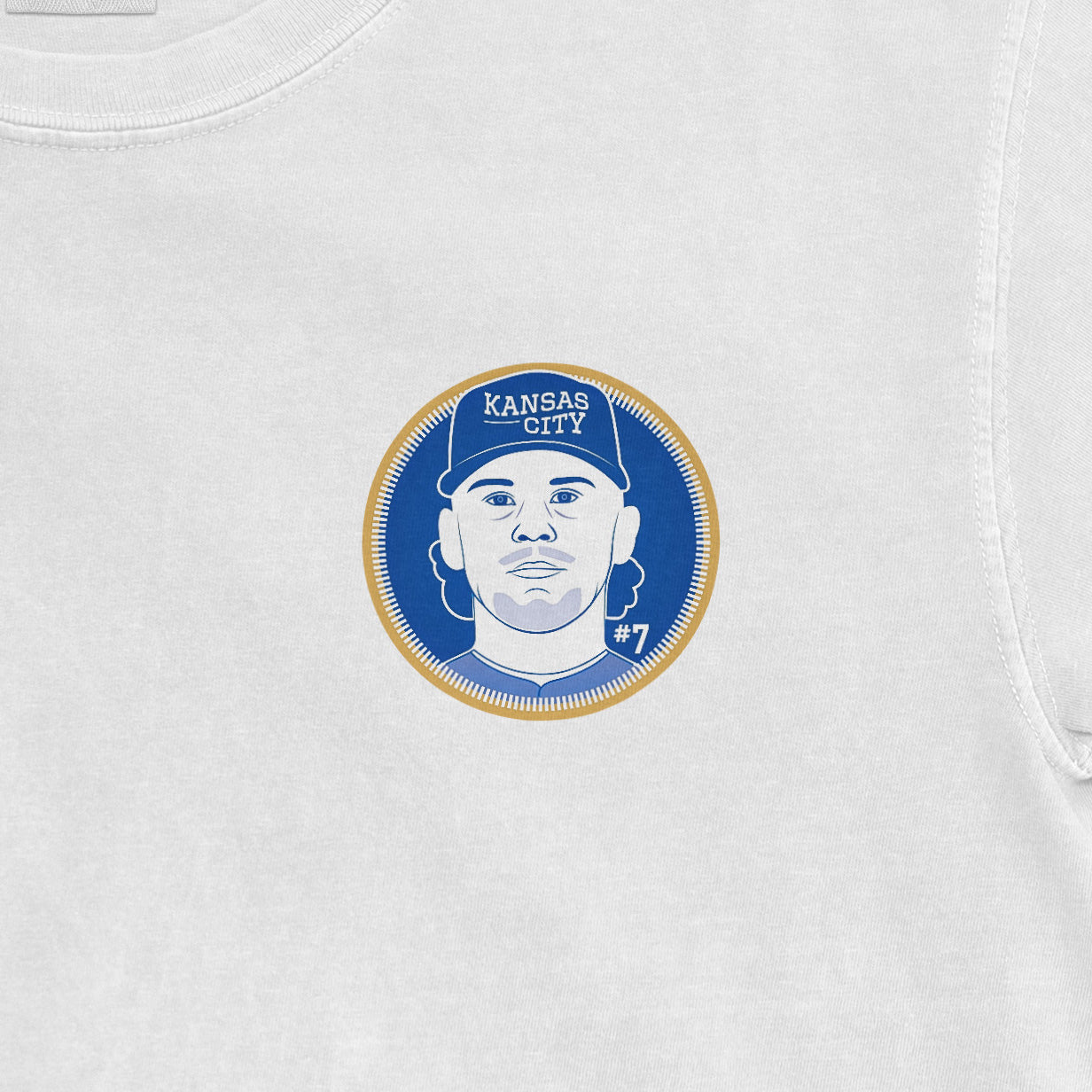 White Comfort Colors tee featuring a graphic of Bobby Witt Jr. with "Kansas City" and "#7" on a blue and gold circular design.