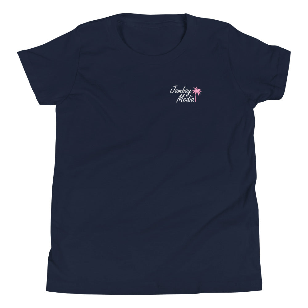 Navy youth T-shirt with "Greetings from Jomboy Media" text and pink palm tree graphic on the chest.