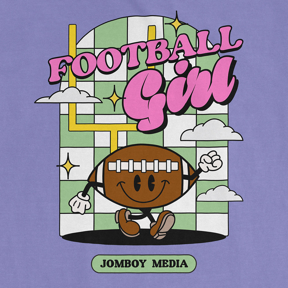 Colorful graphic tee featuring a cartoon football character with a smiling face, surrounded by clouds and stars, with "Football Girl" text.