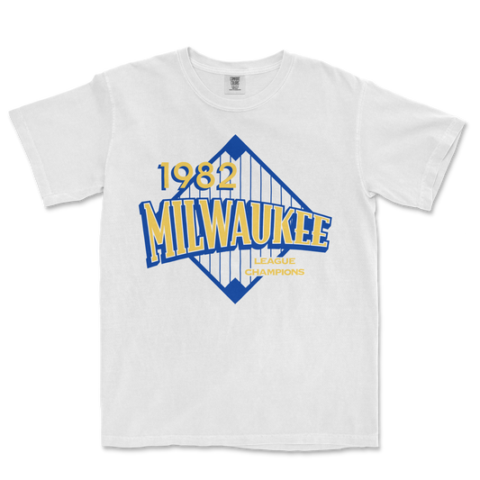 White Comfort Colors T-shirt featuring a vintage Milwaukee Brewers 1982 league champions graphic design in blue and yellow.