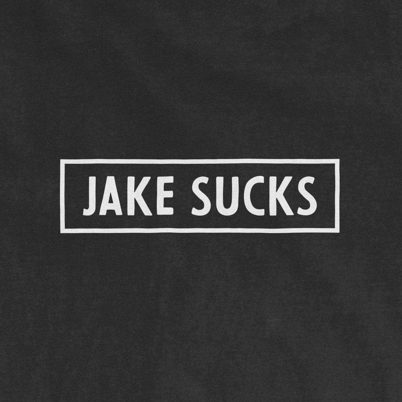 Black Comfort Colors® vintage tee with white rectangular outline and bold text that reads "JAKE SUCKS" in the center.
