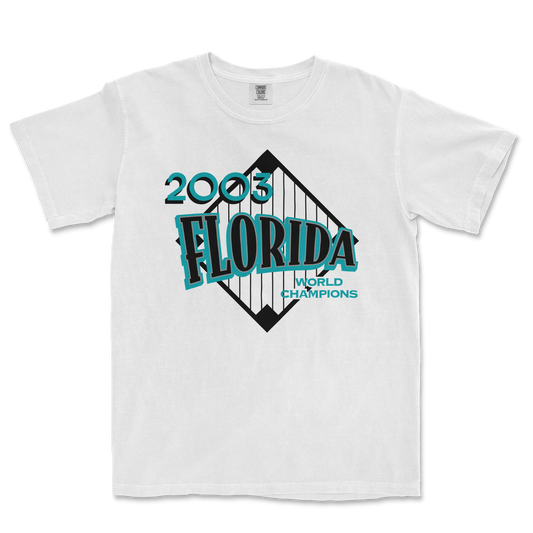 White Comfort Colors tee featuring a 2003 Florida World Champions graphic with a bridge illustration and bold blue and black text.