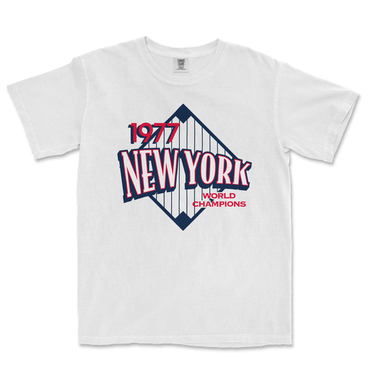 White Comfort Colors T-shirt featuring a vintage New York Yankees design with "1977 World Champions" text and a stylized baseball diamond graphic.