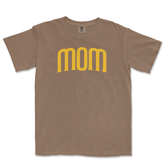 Beige T-shirt with the word "mom" in large, yellow, stylized font across the front, celebrating a San Diego baseball mom.