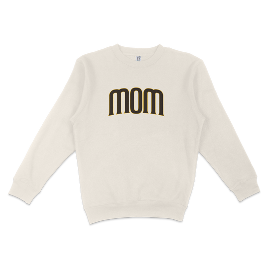 White crewneck sweatshirt with "mom" printed in bold black and gold lettering on the front, designed for San Diego baseball moms.