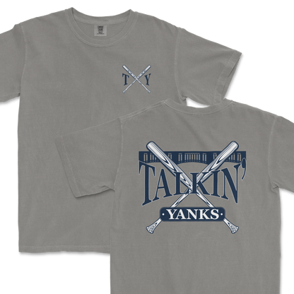 Gray Comfort Colors t-shirt featuring a 'Talkin’ Yanks' graphic with crossed baseball bats and a stylized fence design, with a small logo on the front left chest and a larger version on the back.