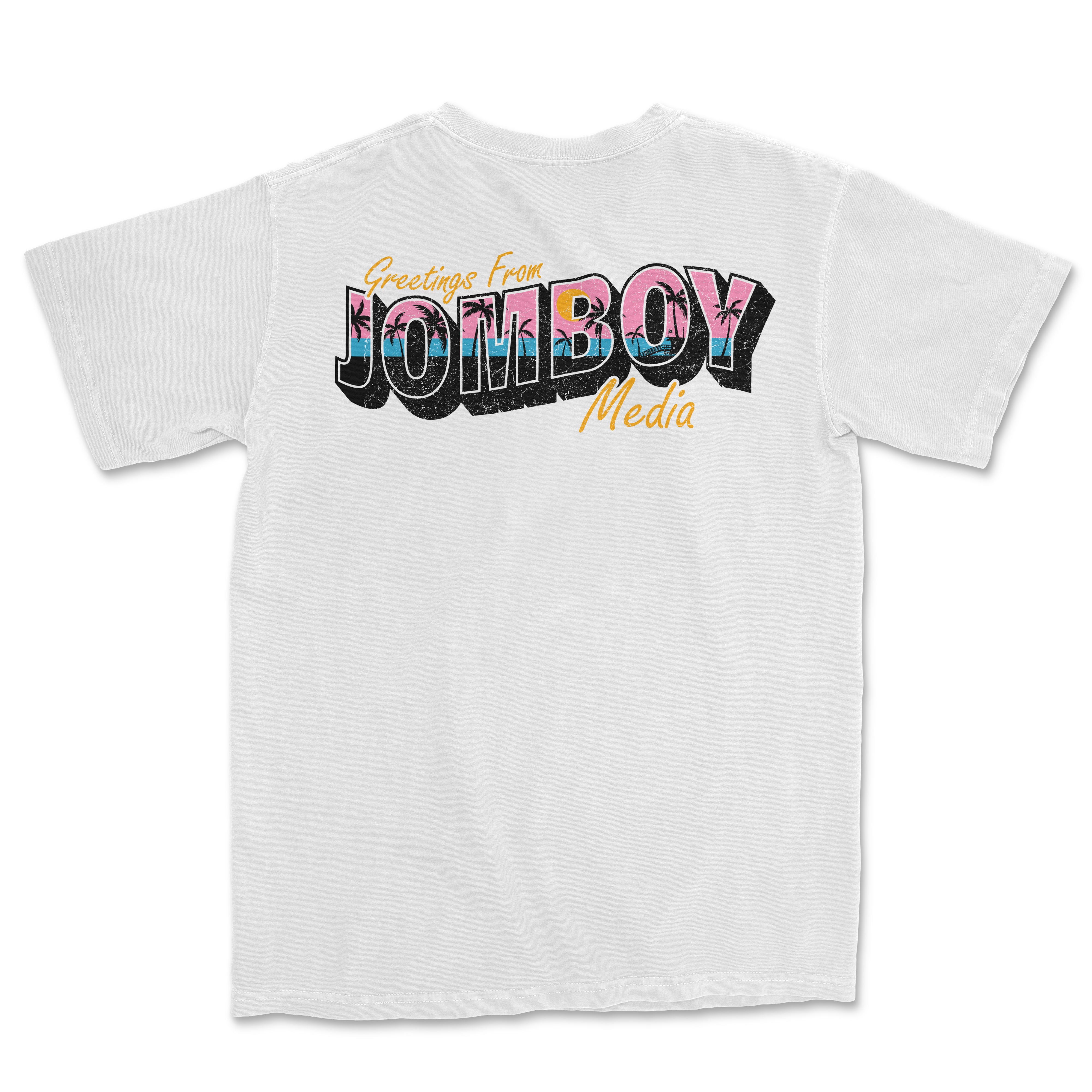 White Comfort Colors T-shirt with colorful "Greetings from Jomboy Media" graphic featuring pink, blue, black, and orange text.