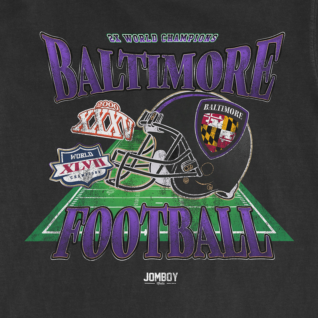 Black Comfort Colors T-shirt featuring a Baltimore football design with a helmet, football field, and championship logos.