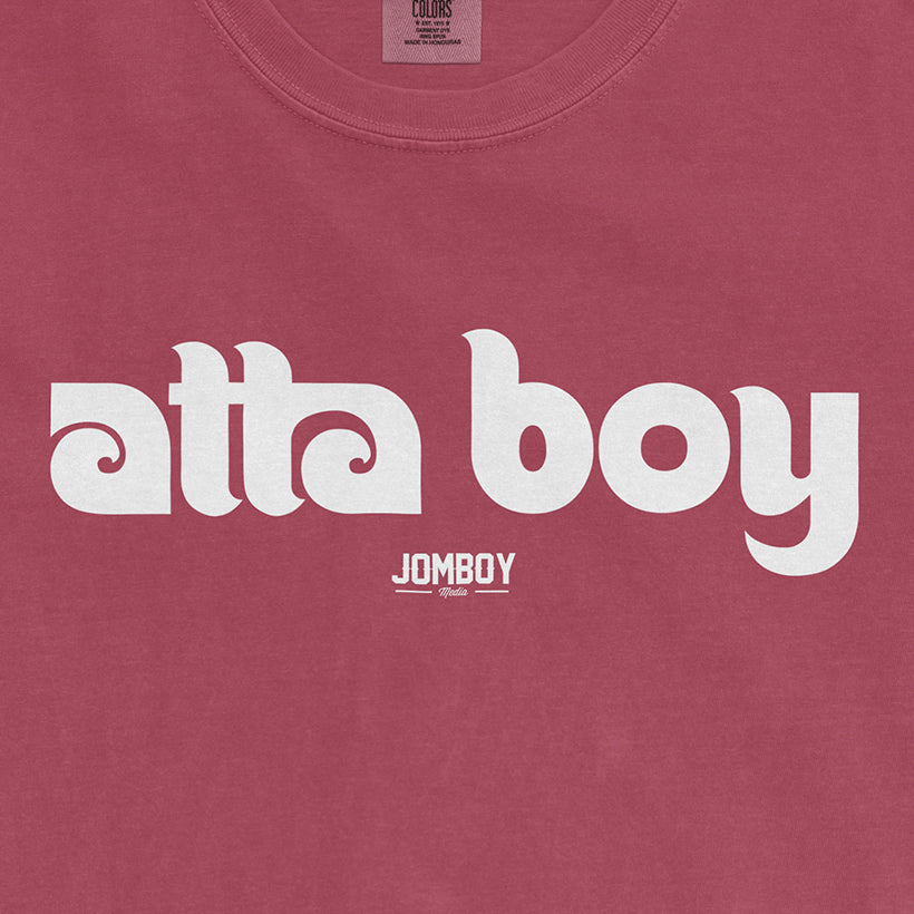 Pink Comfort Colors T-shirt with white "atta boy" text and a small "JOMBOY" logo below.