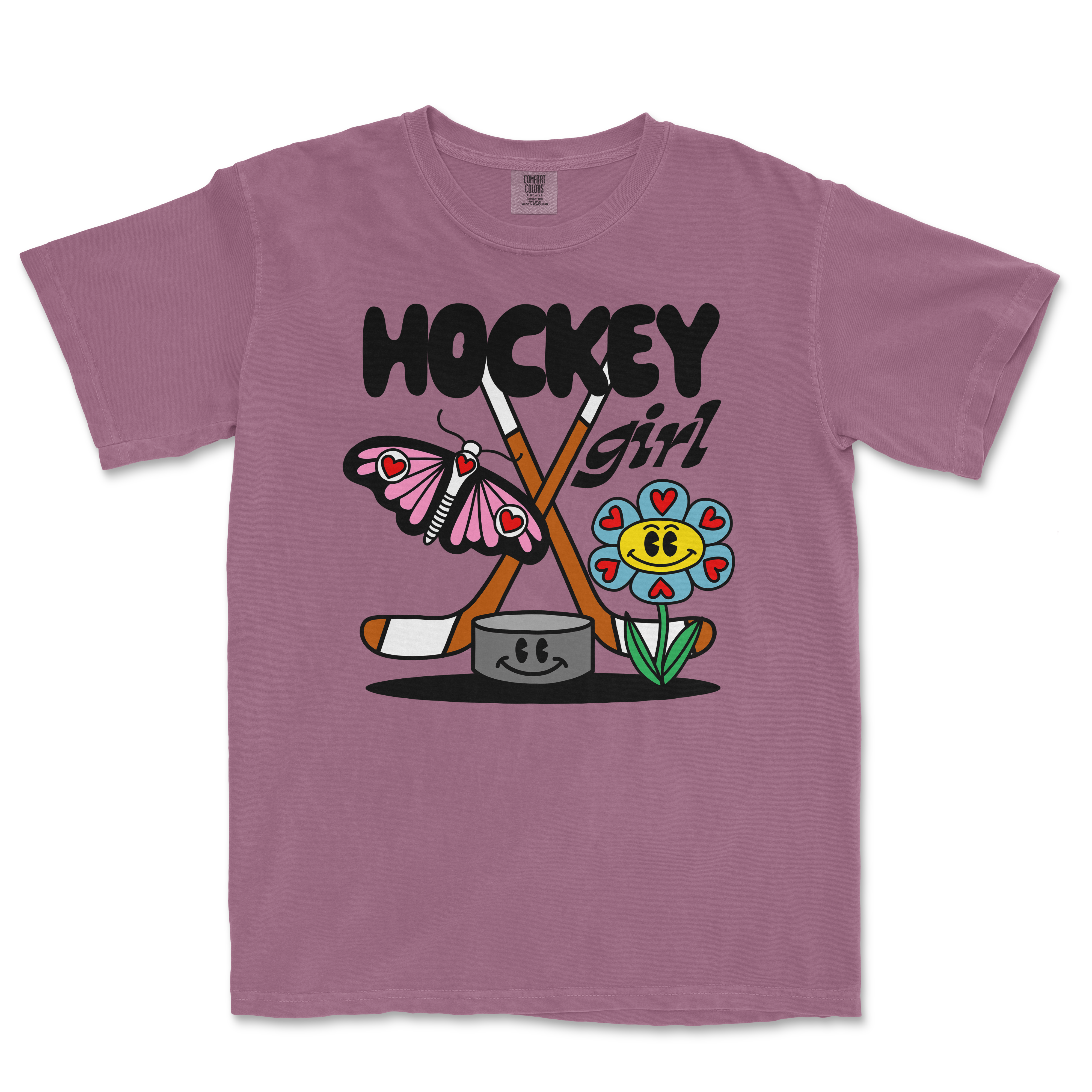Pink Comfort Colors tee featuring a colorful cartoon design with a butterfly, flower, hockey sticks, and the text "Hockey Girl.