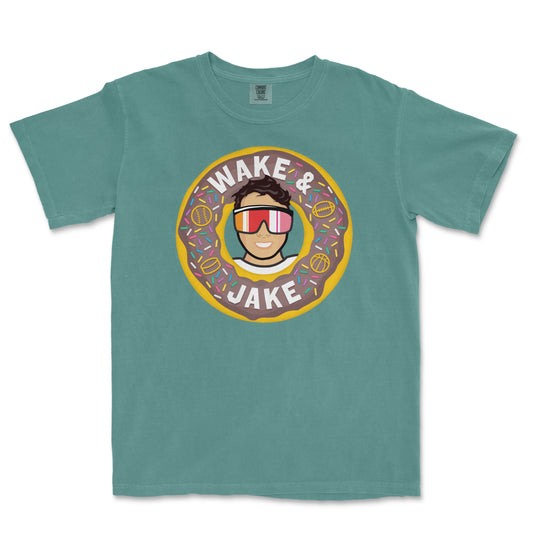 T-shirt featuring a cartoon person wearing sunglasses inside a donut with sprinkles, with the text "Wake & Jake" above and below.