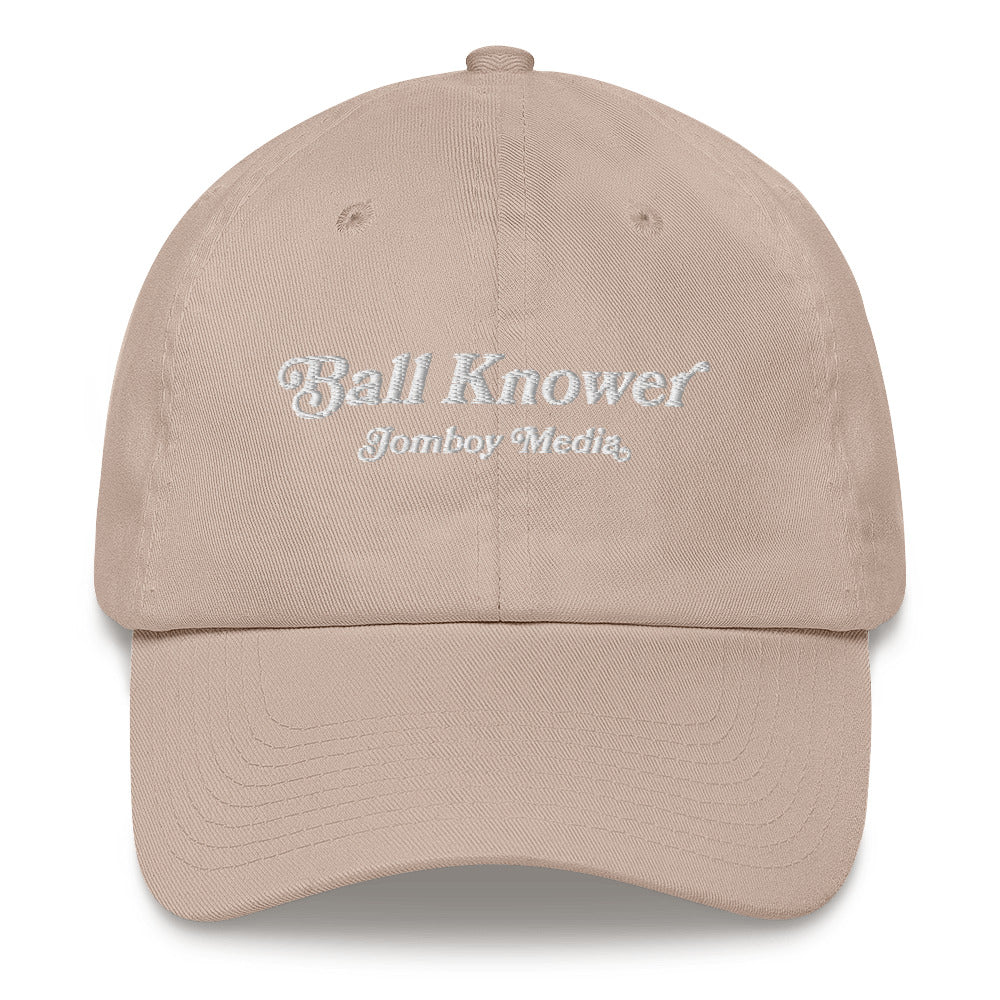 Beige dad hat with "Ball Knower" and "Jomboy Media" embroidered in white on the front, featuring a curved brim and adjustable strap.
