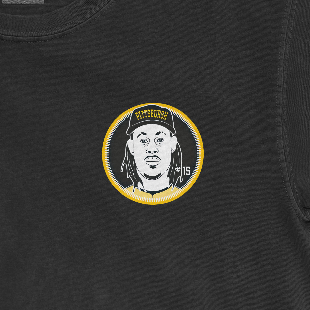 Black shirt featuring a circular graphic of a person with dreadlocks, wearing a cap with "Pittsburgh" and the number 15.