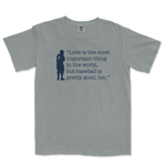 Gray Comfort Colors T-shirt featuring a navy silhouette of a baseball player and the quote: "Love is the most important thing in the world, but baseball is pretty good, too.