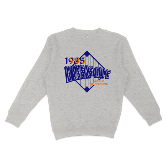 Gray crewneck sweatshirt featuring a Kansas City Royals graphic with "1985 World Champions" text and a stylized city skyline.