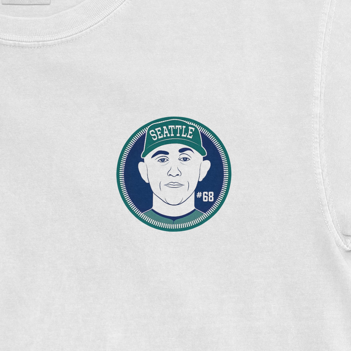 Close-up of a white Comfort Colors tee featuring a graphic of George Kirby with "Seattle" and "#68" on a circular badge.