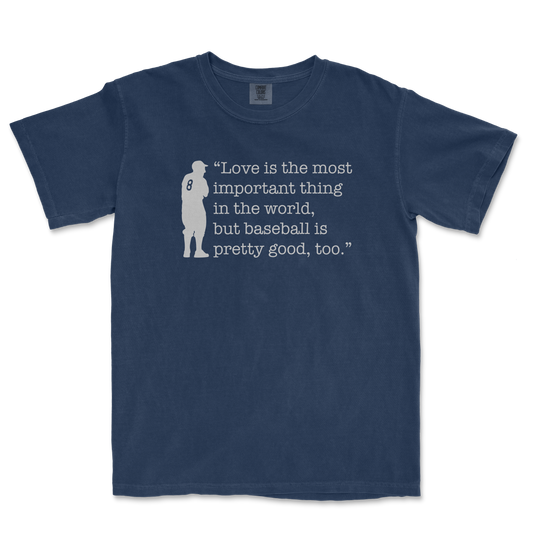 Blue Comfort Colors T-shirt featuring a silhouette of a baseball player and the quote: "Love is the most important thing in the world, but baseball is pretty good, too.