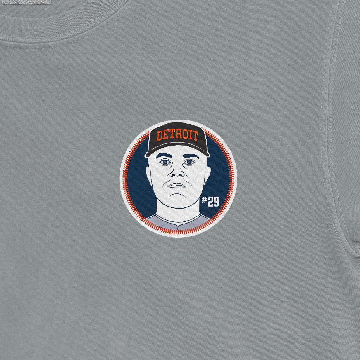 Gray shirt featuring a circular graphic of a person wearing a "Detroit" cap, with "#29" and a serious expression.