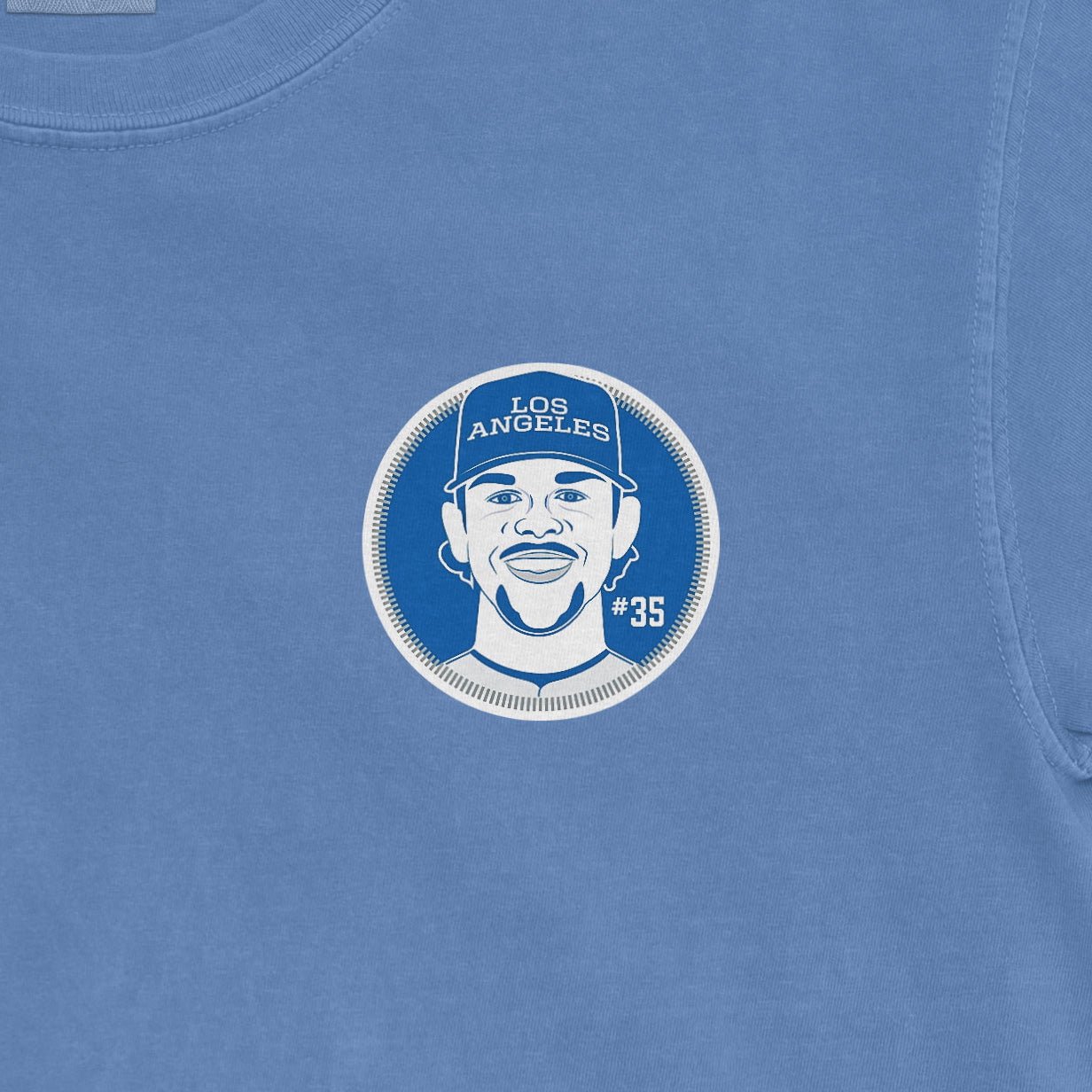 Blue Comfort Colors T-shirt featuring a graphic of a smiling man wearing a "Los Angeles" cap, with "#35" on the side.