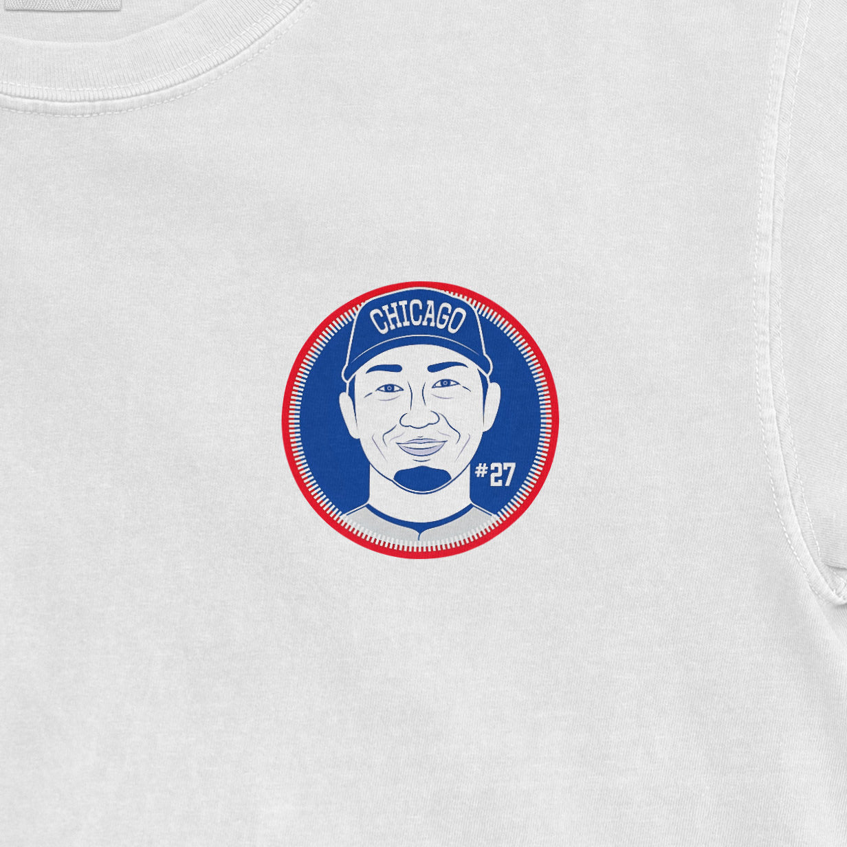 Close-up of a white Seiya Suzuki Shirsey featuring a circular graphic of a smiling player wearing a Chicago cap, with "#27" on the shirt.