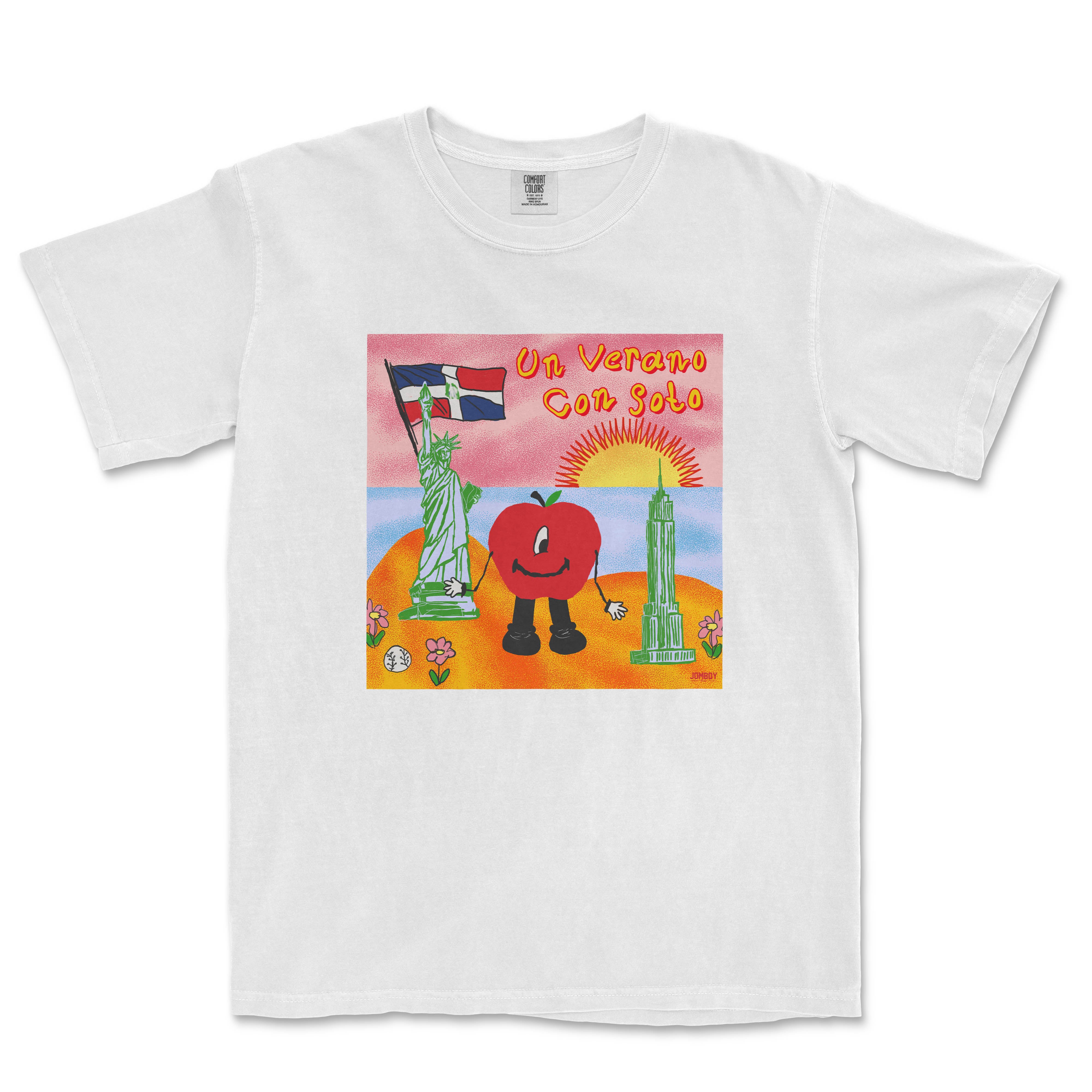 White T-shirt featuring colorful artwork of a smiling tomato character holding a flag, with a sunset, Statue of Liberty, and skyscraper in the background.