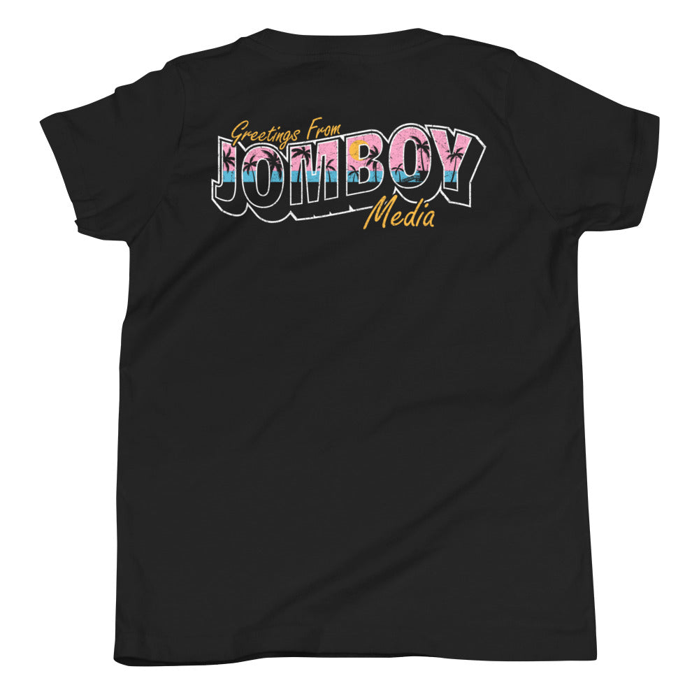 Black youth T-shirt with colorful "Greetings from Jomboy Media" text and yellow cursive accents.