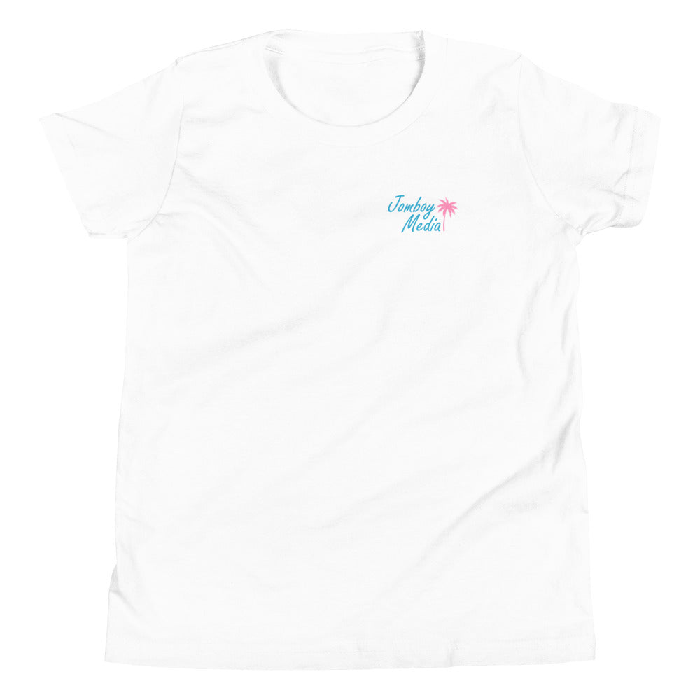 White youth T-shirt with "Jomboy Media" text in blue and pink, featuring a pink palm tree graphic on the upper left chest.