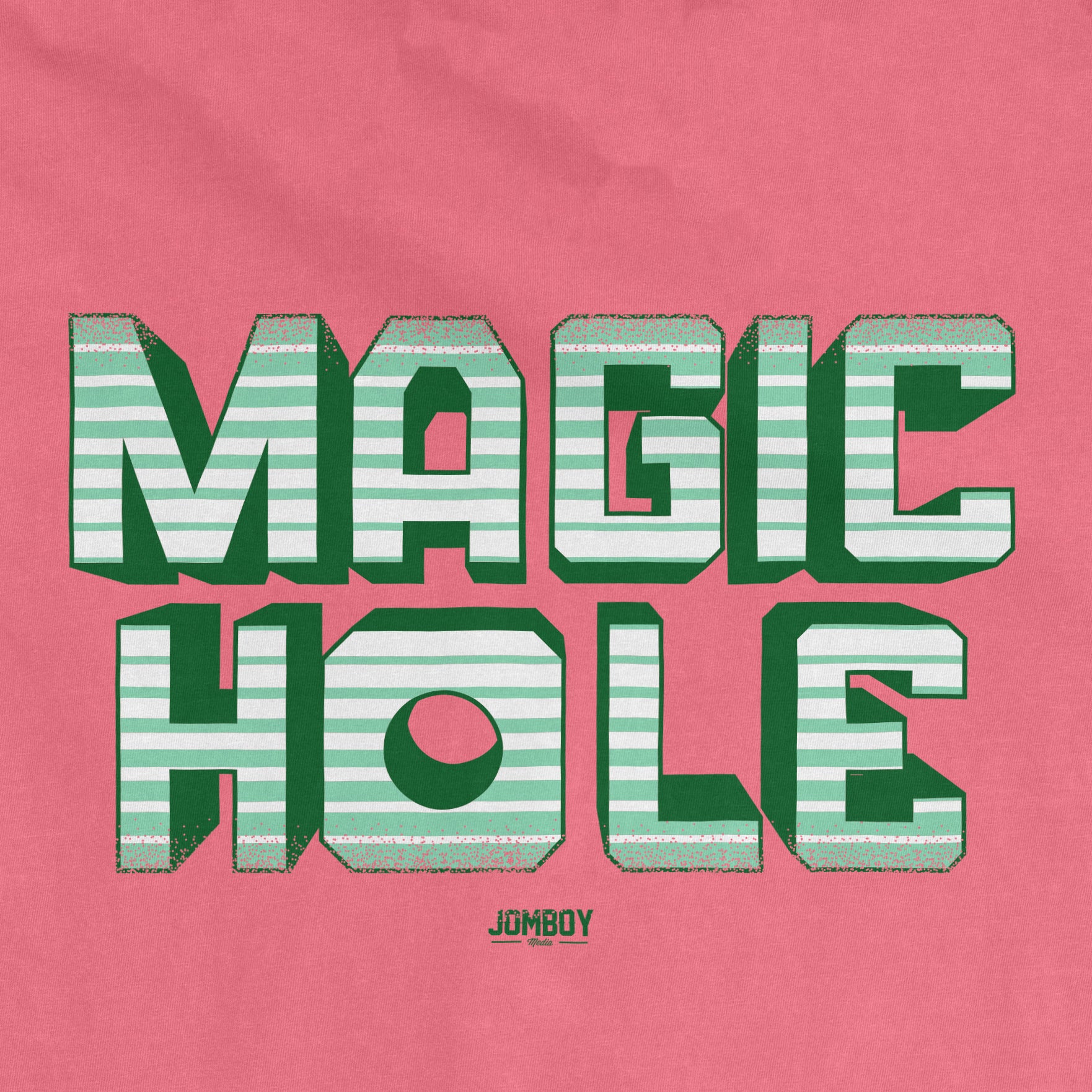 Pink vintage Comfort Colors® T-shirt featuring bold, striped "MAGIC HOLE" text with a 3D effect and small "JOMBOY" logo below.