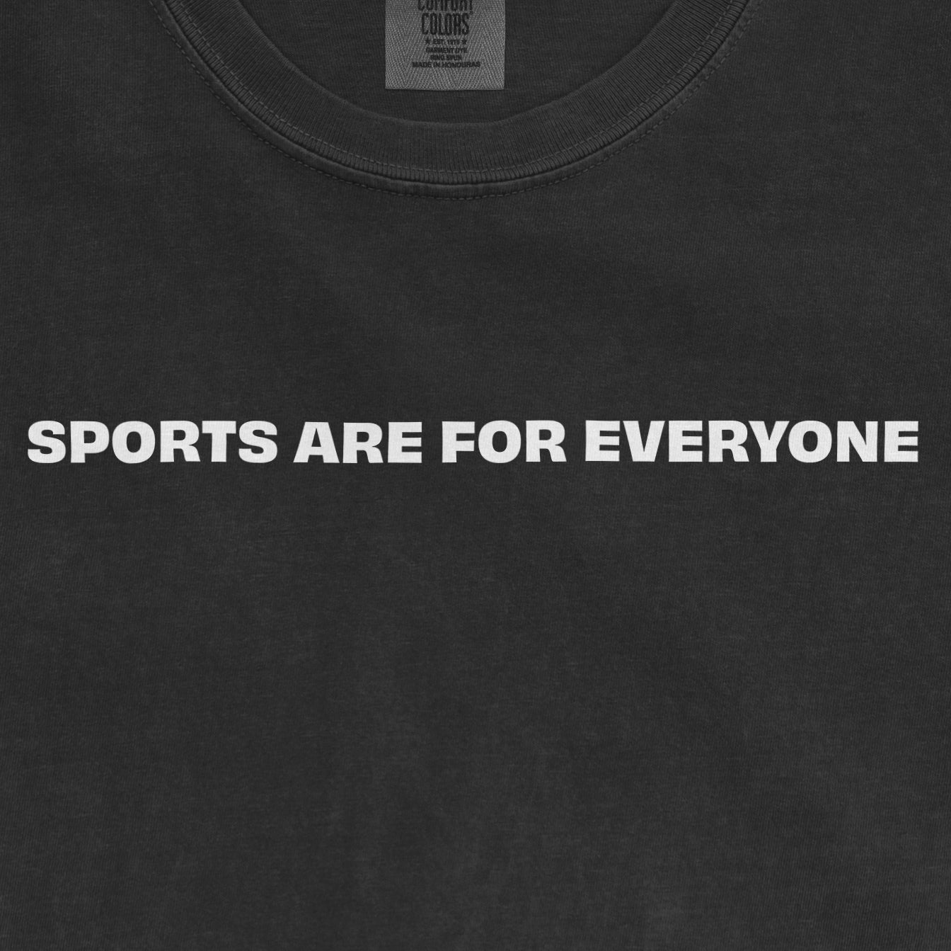 Close-up of a black T-shirt with the bold white text "SPORTS ARE FOR EVERYONE" emphasizing inclusivity in sports.