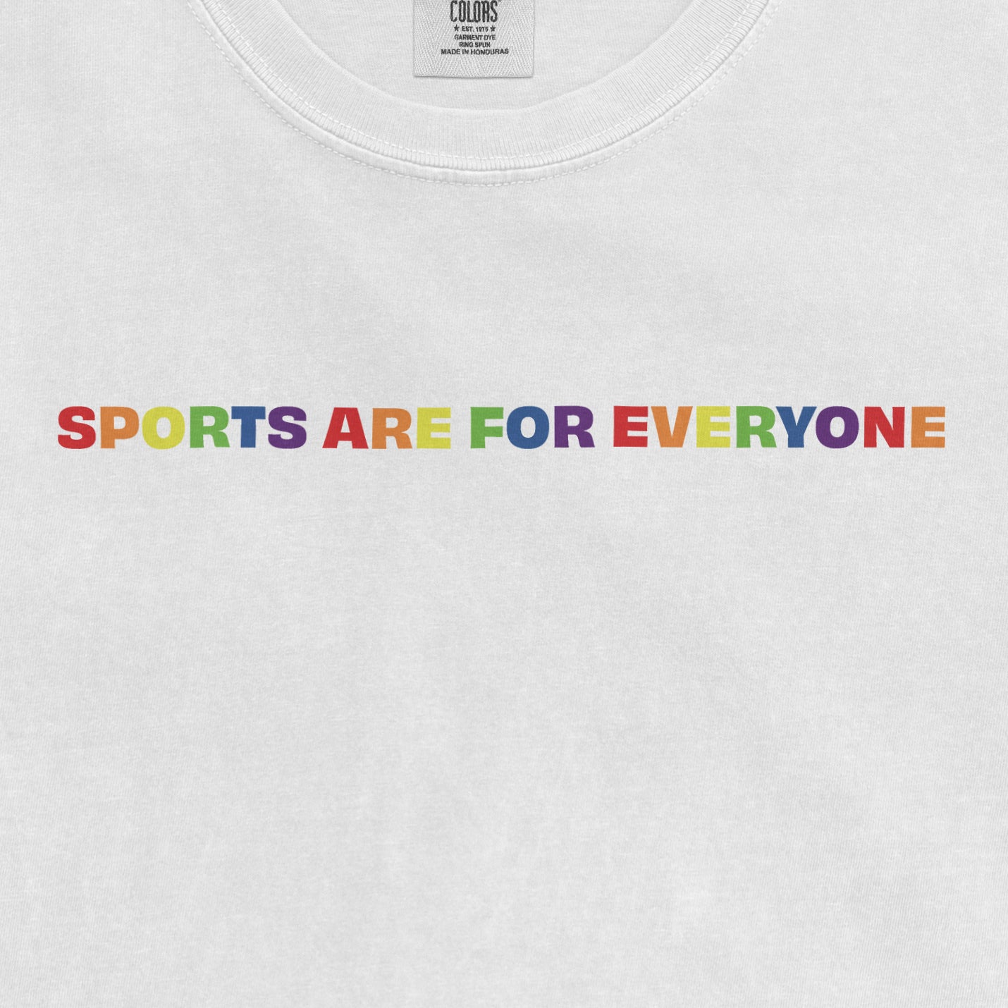 White T-shirt with colorful, rainbow-themed text that reads "SPORTS ARE FOR EVERYONE," promoting inclusivity in sports.