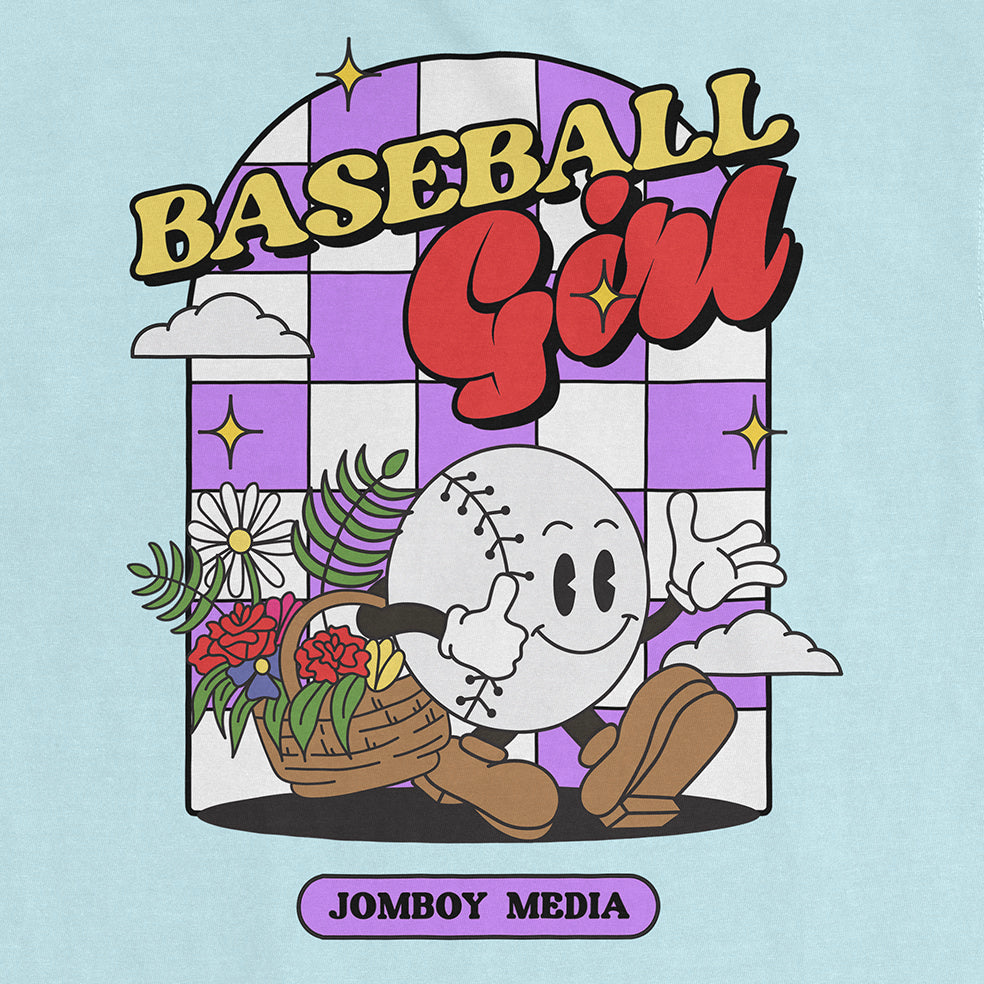Colorful graphic of a smiling baseball character with a flower basket, "Baseball Girl" text, and "Jombo Media" label on a Comfort Colors tee.