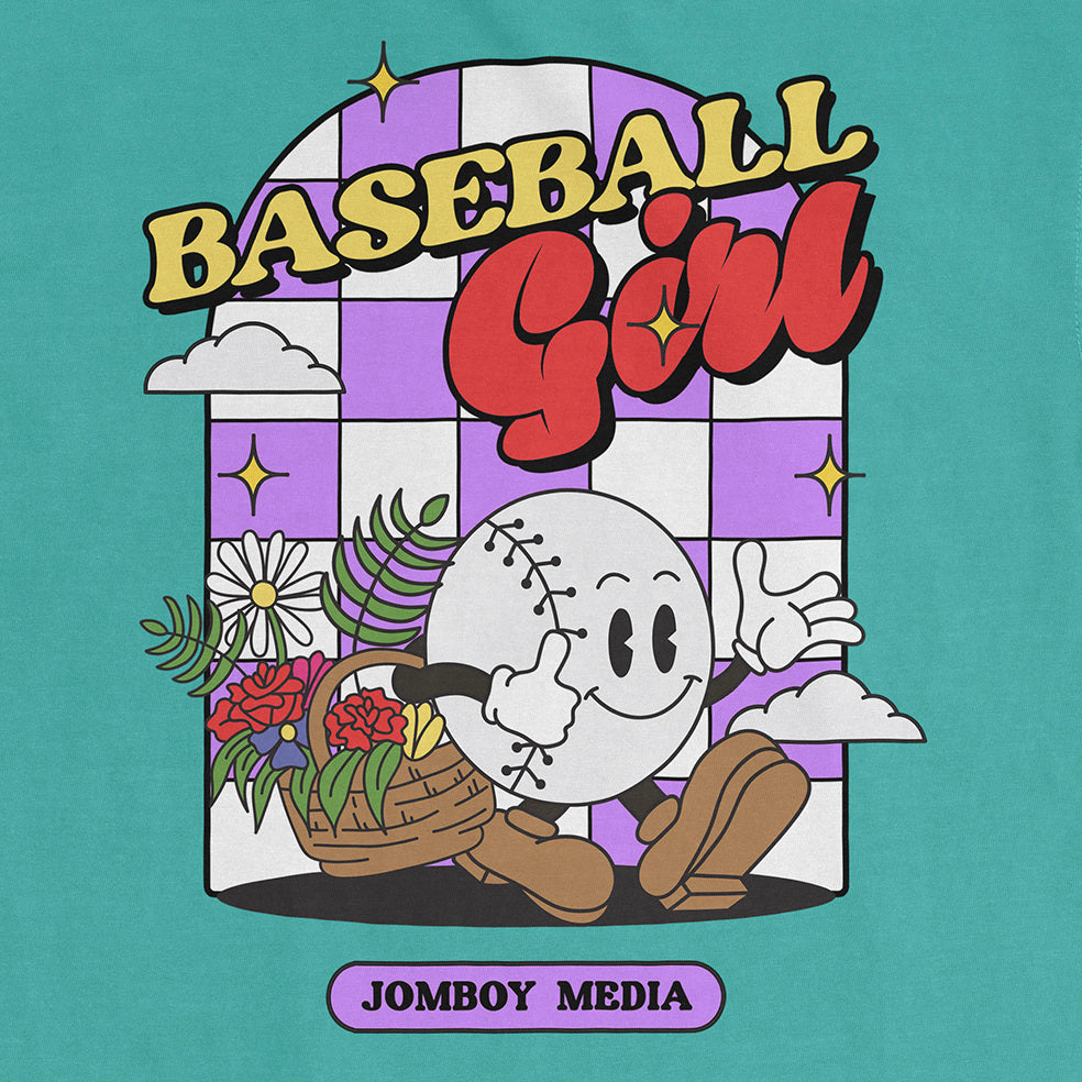 Colorful graphic of a smiling baseball character with a flower basket, surrounded by clouds and stars, on a Comfort Colors tee.