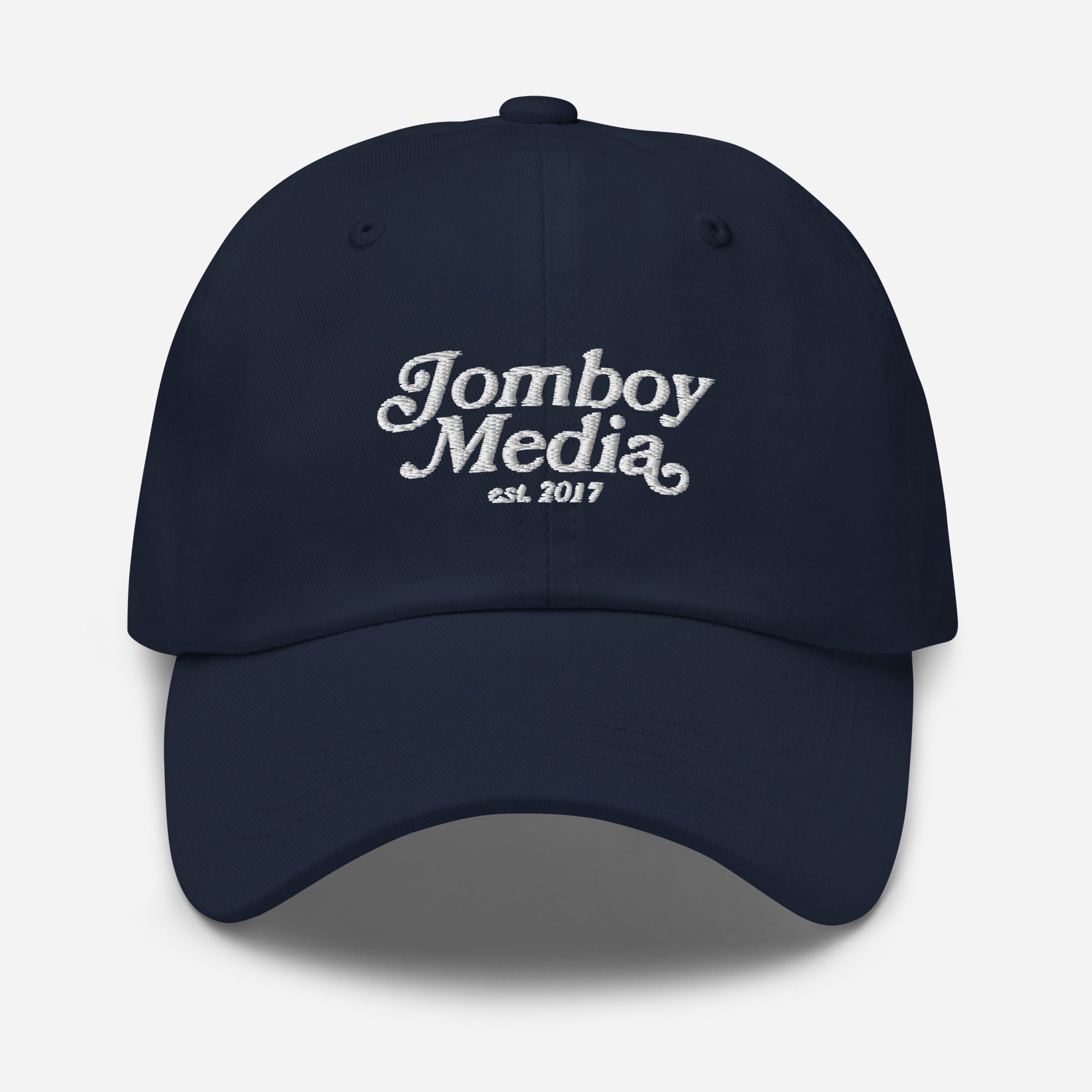 Navy blue dad hat with white embroidered "Jomboy Media" logo and "est. 2017" text on front, featuring a curved brim and adjustable strap.